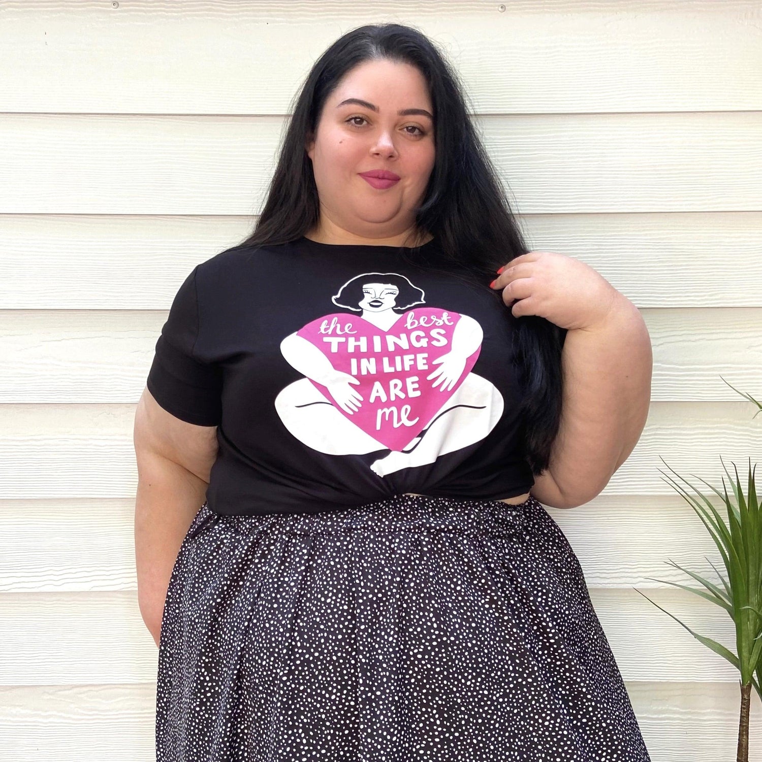 Schwarzes Viskose-T-Shirt mit dem Slogan „Simply the Best“ in fetter, weißer und pinker Retro-Schrift.